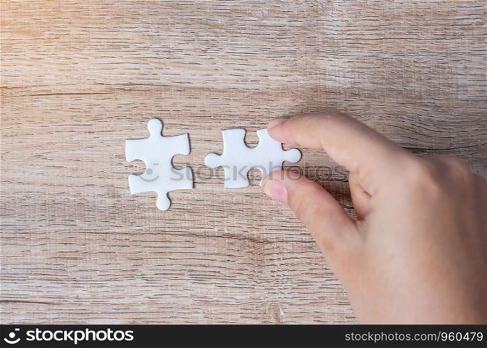 Businessman hand connecting couple puzzle piece. Business solutions, mission target, successful, goals, cooperation, partnership and strategy concept