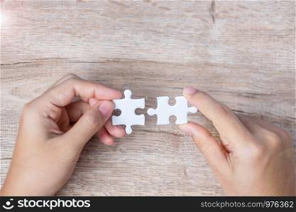 Businessman hand connecting couple puzzle piece. Business solutions, mission target, successful, goals, cooperation, partnership and strategy concept