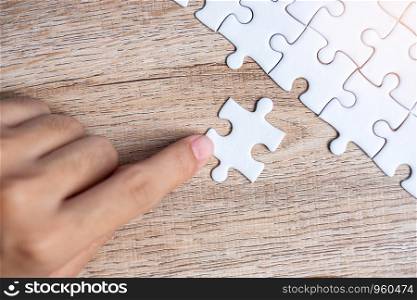 Businessman hand connecting puzzle piece. Business solutions, mission target, successful, goals, cooperation, partnership and strategy concept