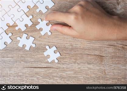 Businessman hand connecting puzzle piece. Business solutions, mission target, successful, goals, cooperation, partnership and strategy concept