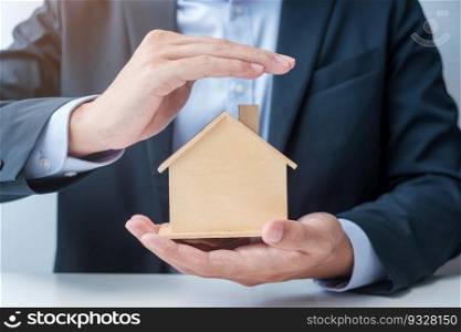 Businessman hand cover wooden Home model. real estate, insurance and property concepts