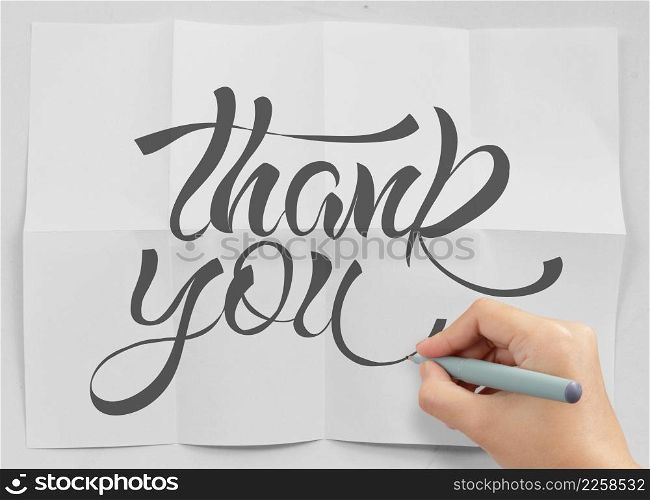 businessman hand drawing design word THANK YOU on crumpled paper as concept