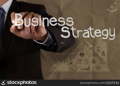 businessman hand draws business strategy with crumpled recycle paper background as concept