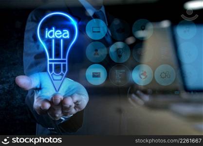 businessman hand draws lightbulb with new computer interface as solution business concept