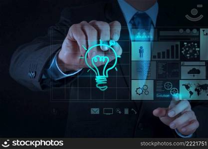 businessman hand draws lightbulb with new computer interface as strategy business concept