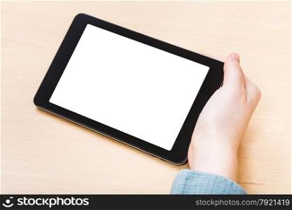 businessman hand hold tablet PC with cutout screen at office table