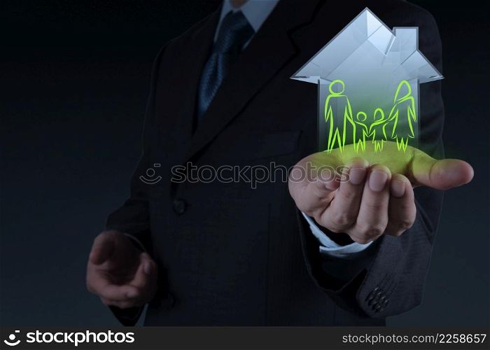 businessman hand holding 3d house wtih family icon as insurance concept