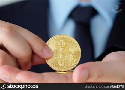 Businessman hand holding bitcoin, close up, finance, cryptocurrency and blockchain concept