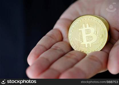 Businessman hand holding bitcoins, cryptocurrency and blockchain concept, business finance and technology
