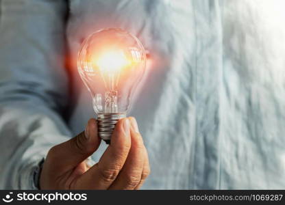 businessman hand holding lightbulb. idea Alternative energy concept saving electricity