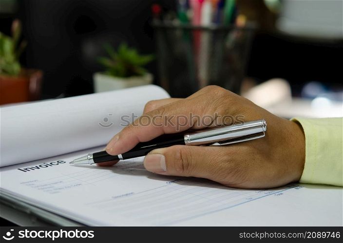 businessman hand holding pen at billing document.Business Finance and Marketing