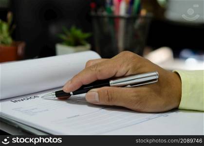 businessman hand holding pen at billing document.Business Finance and Marketing