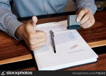 businessman Hand notary public hand ink appoval stamper Stamping seal On Approved Contract Form documents contract, loan money concept