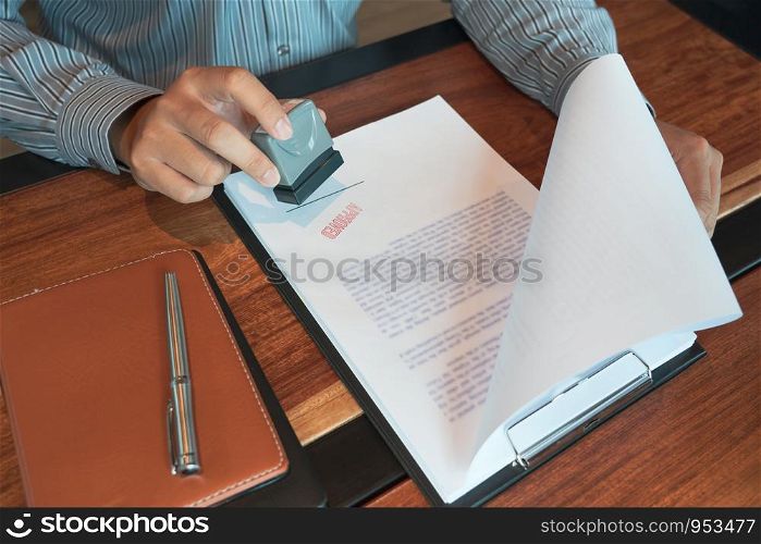 businessman Hand notary public hand ink appoval stamper Stamping seal On Approved Contract Form documents contract, loan money concept