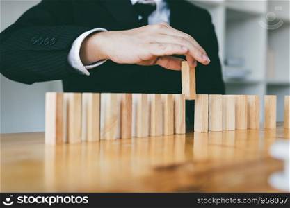 Businessman hand pick one of wood block in row with leadership concept