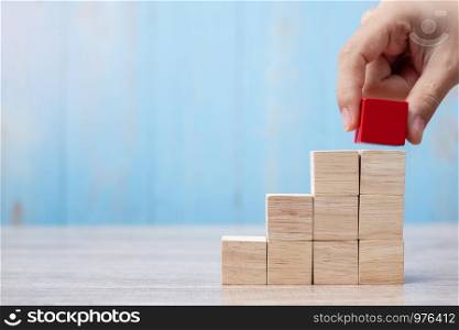 Businessman hand placing or pulling Red wooden block on the building. Business planning, Risk Management, Solution, strategy, different and Unique Concepts