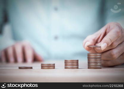 Businessman hand putting money coin stack plan growing business , Growing up business and saving money concepts