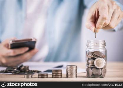 Businessman hand putting money coin stack plan growing business , Growing up business and saving money concepts