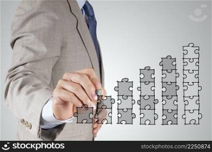 businessman hand puzzle charts with new modern computer and business strategy as concept