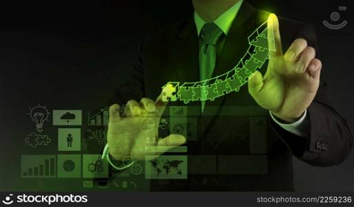 businessman hand puzzle charts with new modern computer and business strategy as concept
