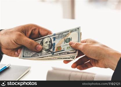 Businessman hand sending money to another business person. Transaction, payment, salary and banking concept.