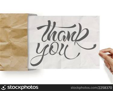 businessman hand show design word THANK YOU on crumpled paper as concept