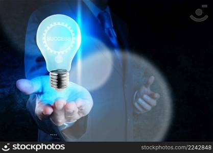 businessman hand showing light bulb with gear of success as concept