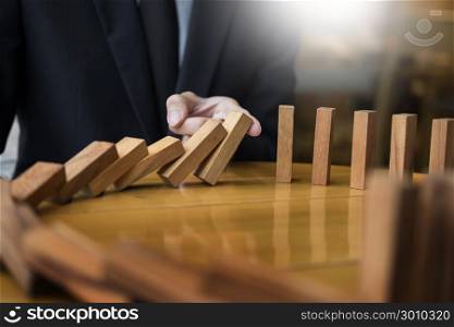 businessman hand stop dominoes continuous toppled or risk with copyspace