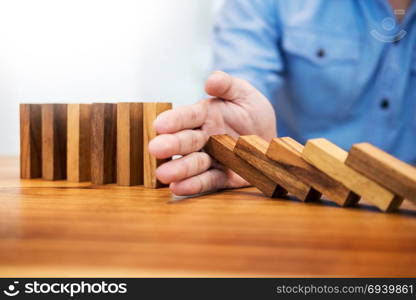 businessman hand stop dominoes continuous toppled or risk with copyspace