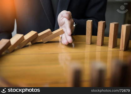 businessman hand stop dominoes continuous toppled or risk with copyspace