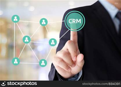 Businessman hand touch CRM, Customer Relationship Management, icon over blur background, success in business concept