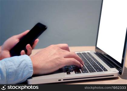 businessman hand typing computer at desk with blank screen mock up