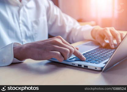 Businessman hand typing on computer keyboard of a laptop computer in office. Business and finance concept.