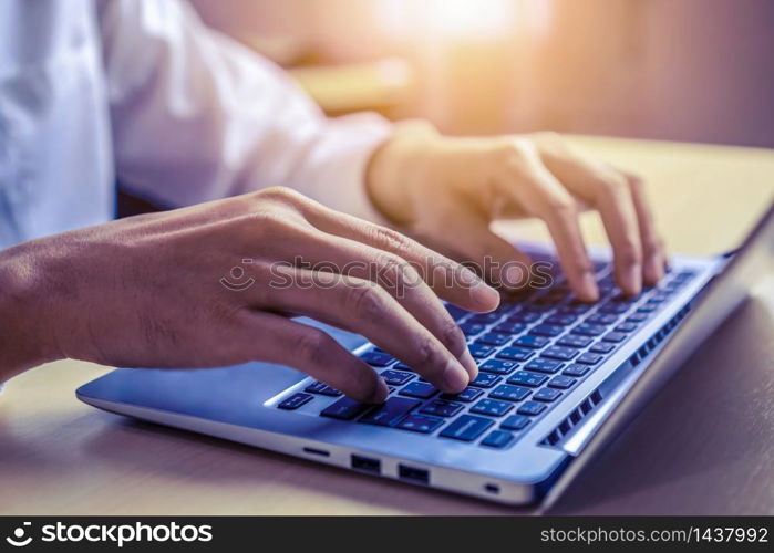 Businessman hand typing on computer keyboard of a laptop computer in office. Business and finance concept.