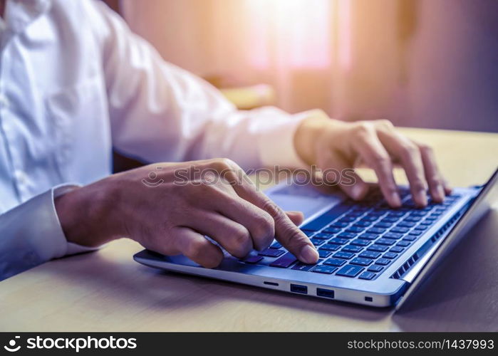 Businessman hand typing on computer keyboard of a laptop computer in office. Business and finance concept.