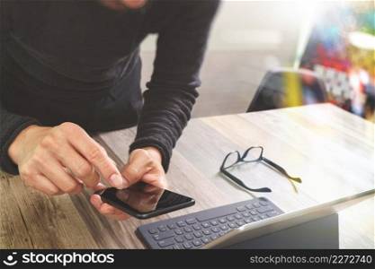 Businessman hand using mobile payments online shopping,omni channel,in modern office wooden desk,icons graphic interface screen,eyeglass,filter effect