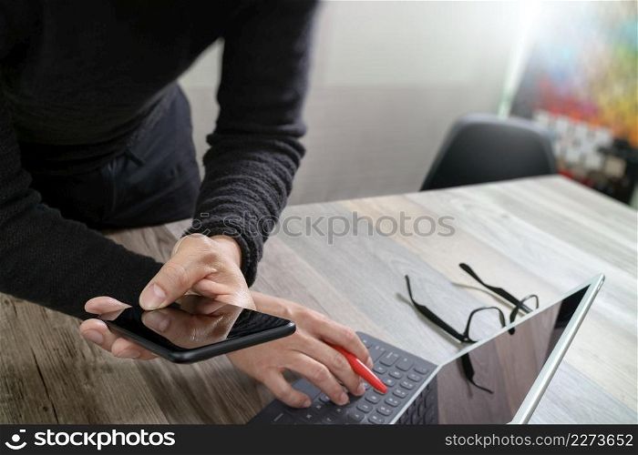Businessman hand using mobile payments online shopping,omni channel,in modern office wooden desk,icons graphic interface screen,eyeglass,filter effect