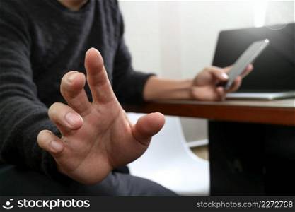 Businessman hand using mobile payments online shopping,pencil,omni channel,laptop computer on wooden desk in modern office 