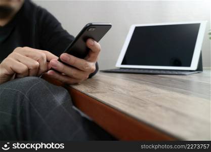businessman hand using smart phone,mobile payments online shopping,omni channel,digital tablet docking keyboard computer in modern office on wooden desk