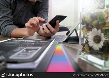 businessman hand using smart phone,mobile payments online shopping,omni channel,digital tablet docking keyboard computer,flower glass vase on wooden desk