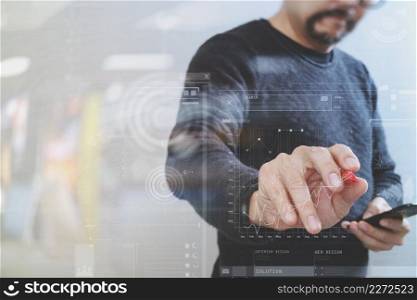 Businessman hand with pen pressing an imaginary button,holding smart phone,digital screen graphic virtual icons,graph,diagram