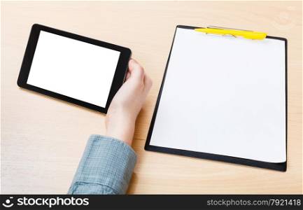 businessman hand with tablet PC with cut out screen at office table