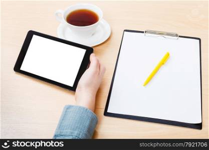 businessman hand with tablet PC with cutout screen at office desk
