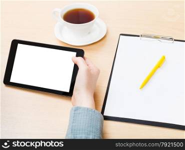 businessman hand with tablet PC with cutout screen at office table