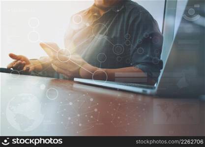 businessman hand working and smart phone and laptop with social media diagram on wooden desk in office
