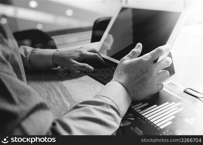Businessman hand working concept. Documents finance graphic chart. Digital tablet keyboard dock screen computer design smart phone using. Sun flare effect, black white