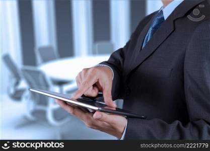 Businessman hand working with a digital tablet on meeting room background