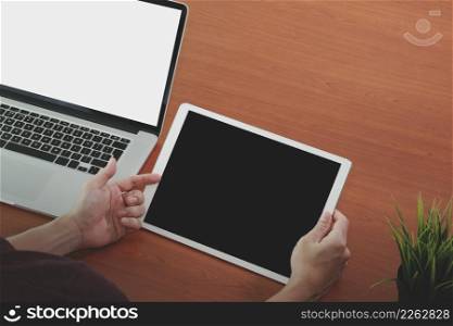 businessman hand working with blank screeen new modern computer laptop and pro digital tablet on wooden desk as concept