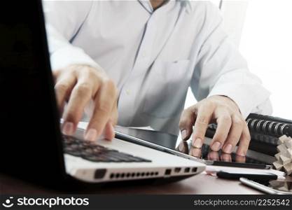businessman hand working with digital tablet and laptop on wooden desk in office