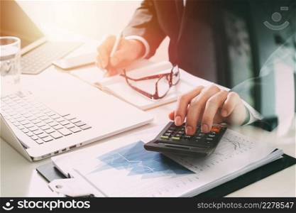 businessman hand working with finances about cost and calculator and latop with mobile phone on withe desk in modern office
